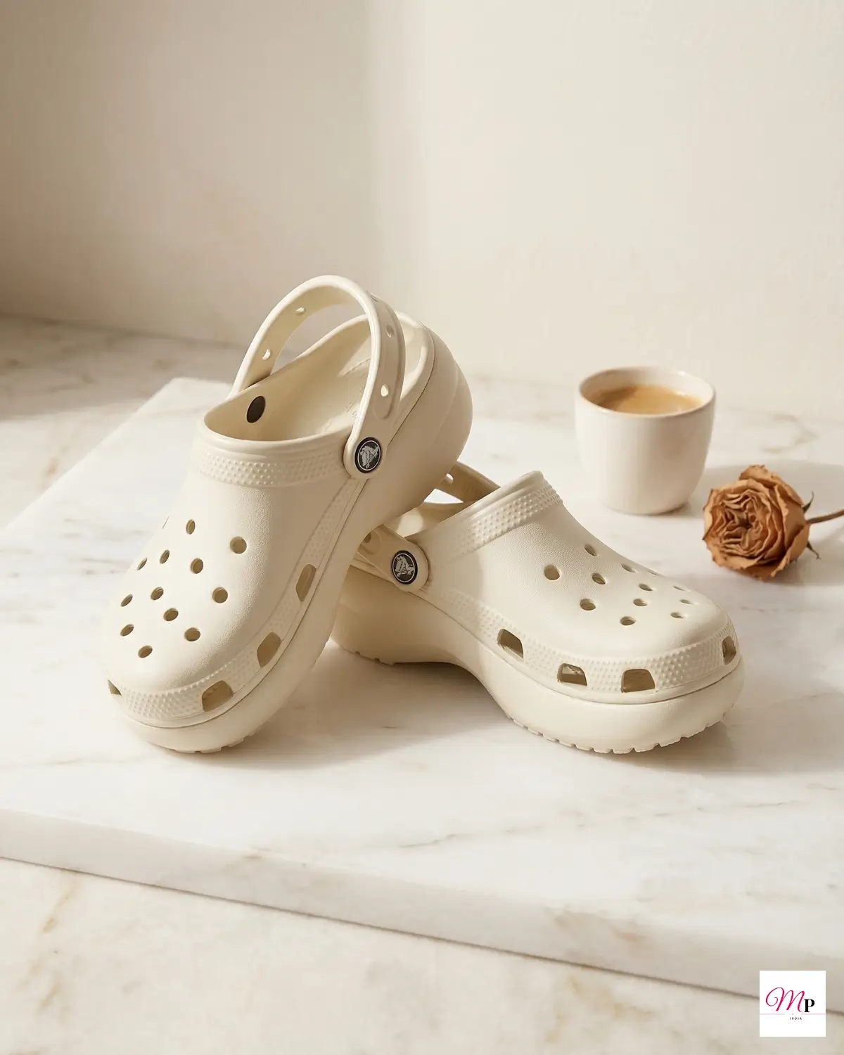 Crocs platform clogs on white marble surface with tea cup and dried rose — comfortable summer footwear India