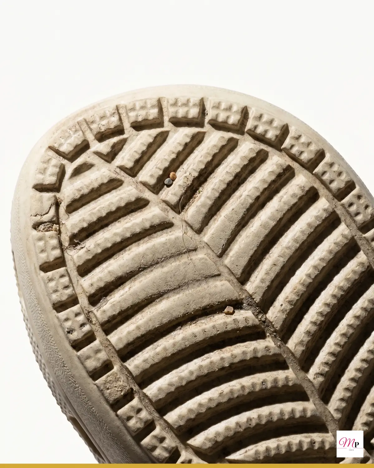 Close-up of Crocs platform clog outsole with Bhubaneswar dust and pebbles embedded in tread grooves — casual footwear wear evidence