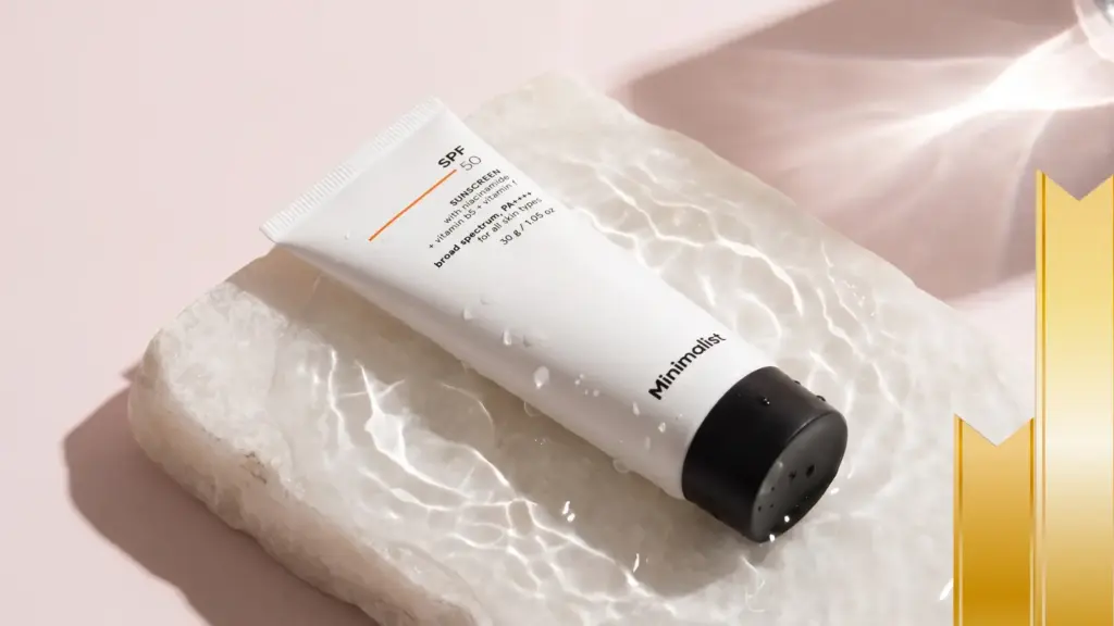 Minimalist SPF 50 sunscreen tube on wet stone slab with water droplets, broad spectrum PA++++ with niacinamide