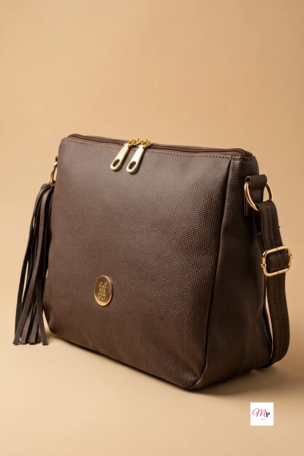 Baggit crossbody bag angled view showing dual gold zippers, adjustable strap buckle, and signature tassel — women handbag India