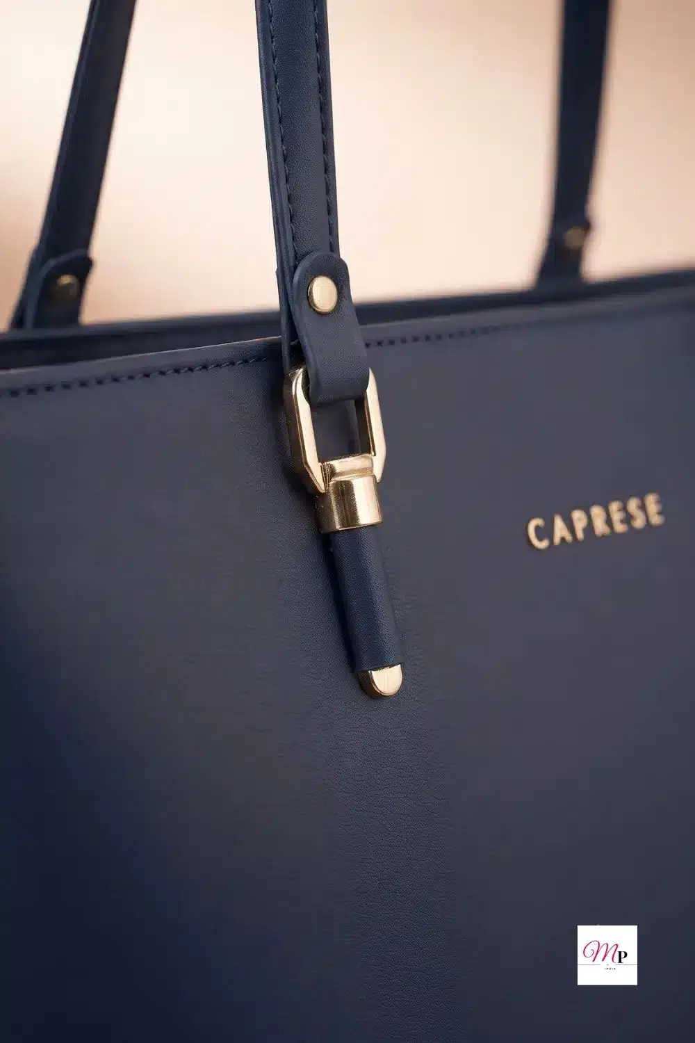 Close-up of gold metal buckle and strap attachment on Caprese faux leather tote bag