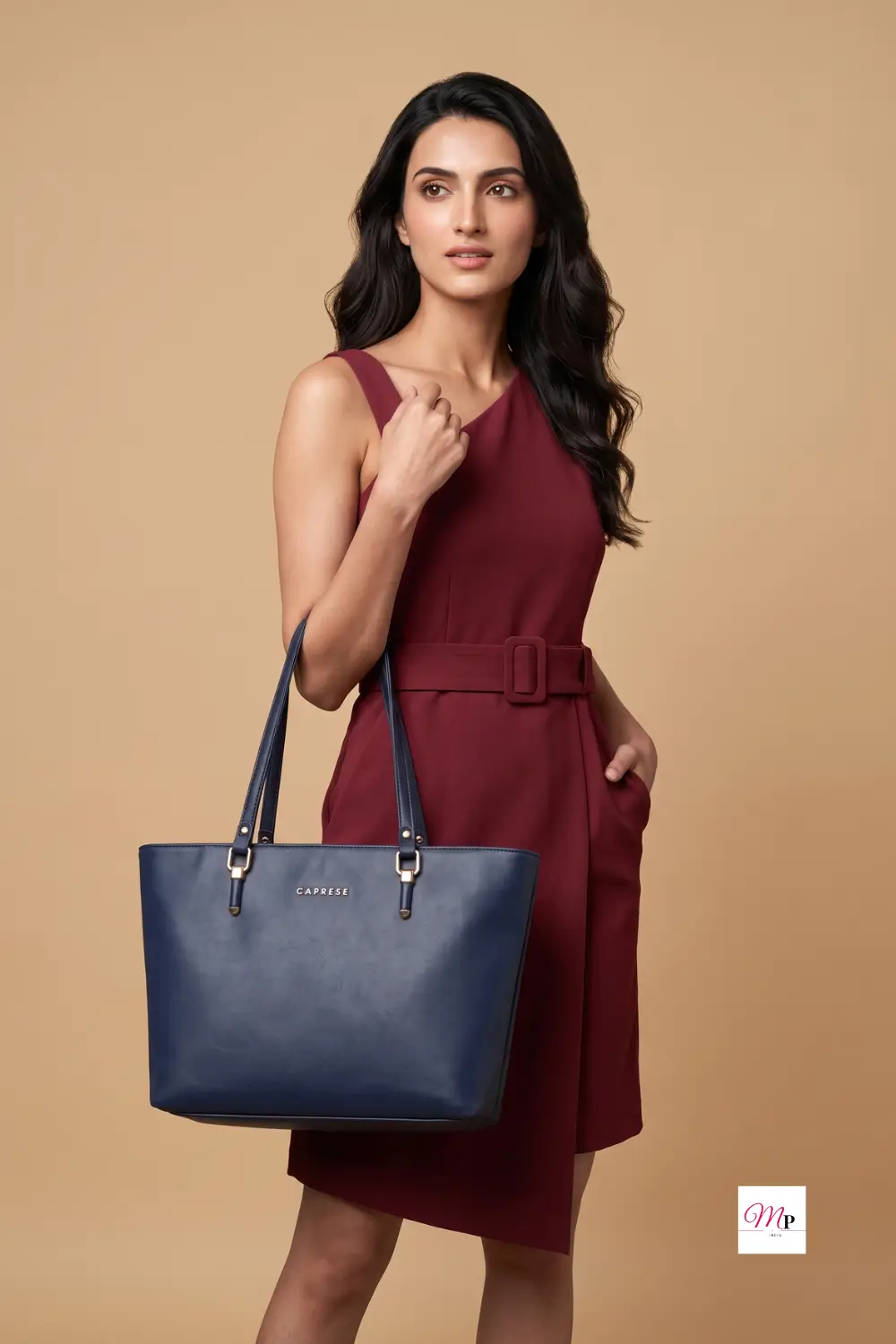Woman in burgundy dress carrying navy blue Caprese laptop tote bag on shoulder