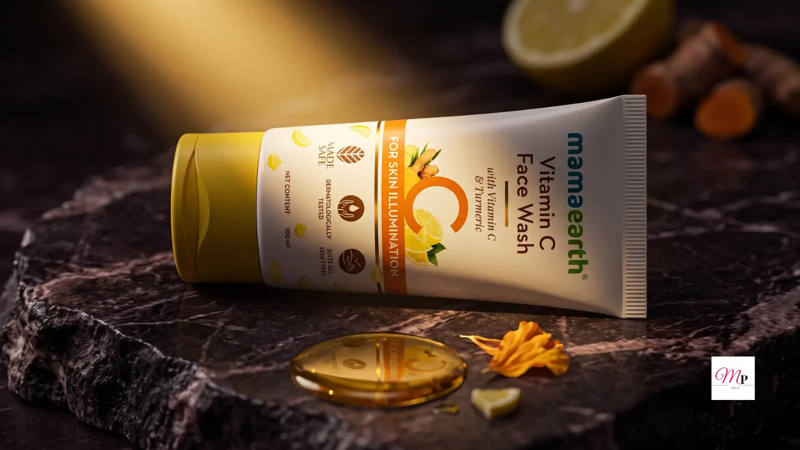 Mamaearth Vitamin C Face Wash with Turmeric 150ml tube on dark marble surface with lemon slices, turmeric roots, and golden oil drop | Mamaearth Vitamin C Face Wash ki tube dark marble surface par nimbu aur haldi ke saath