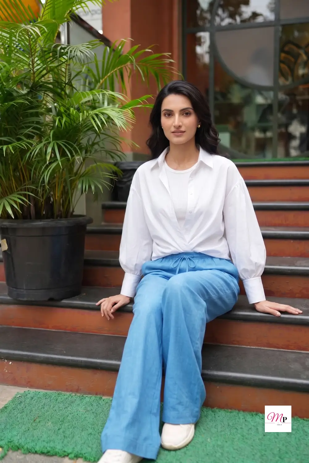 Seated fit test of sky blue linen trousers showing fabric drape and crease pattern after sitting