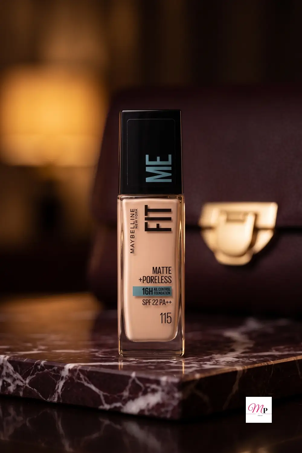 Maybelline Fit Me Foundation on dark marble vanity with burgundy leather handbag and warm ambient lamp light