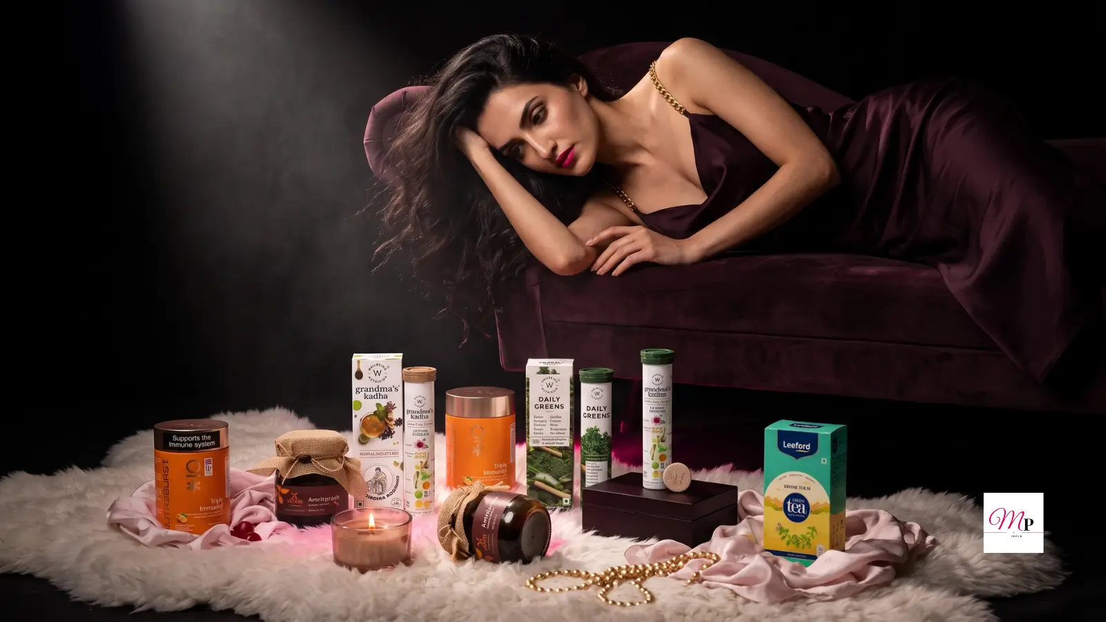 Five curated monsoon immunity products for Indian women including ayurvedic kadha, chyawanprash, vitamin C gummies, daily greens, and tulsi green tea arranged on white fur with moody editorial lighting