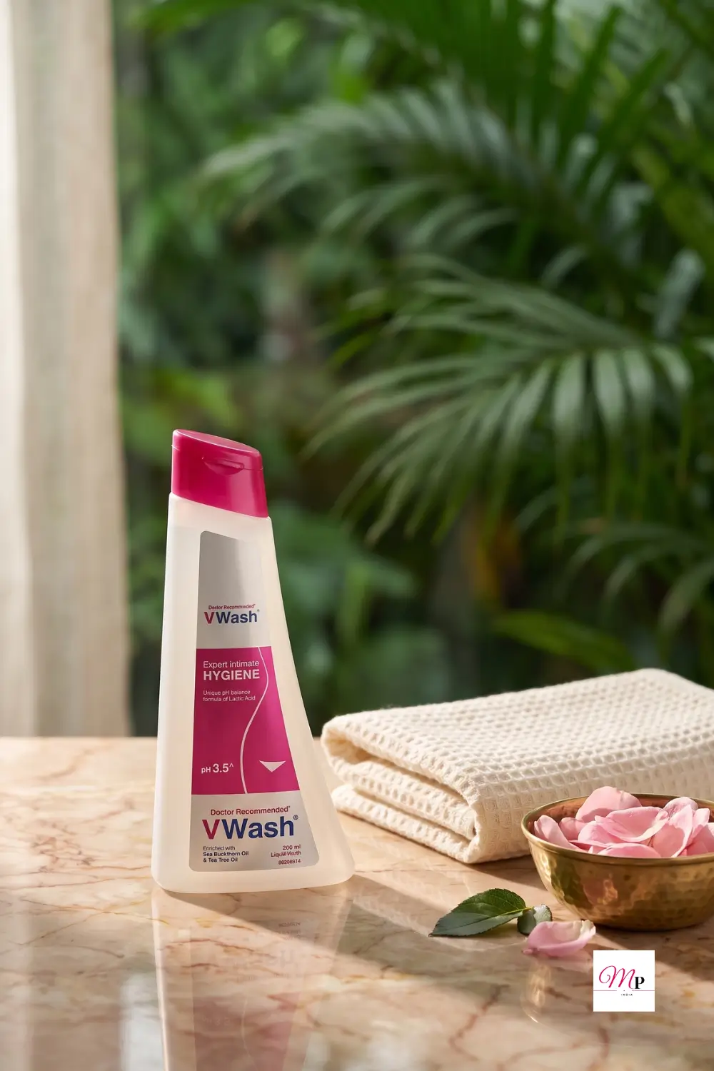 VWash Plus Expert Intimate Hygiene 200ml bottle with pH 3.5 formula and sea buckthorn oil on marble vanity with pink roses for monsoon intimate care women