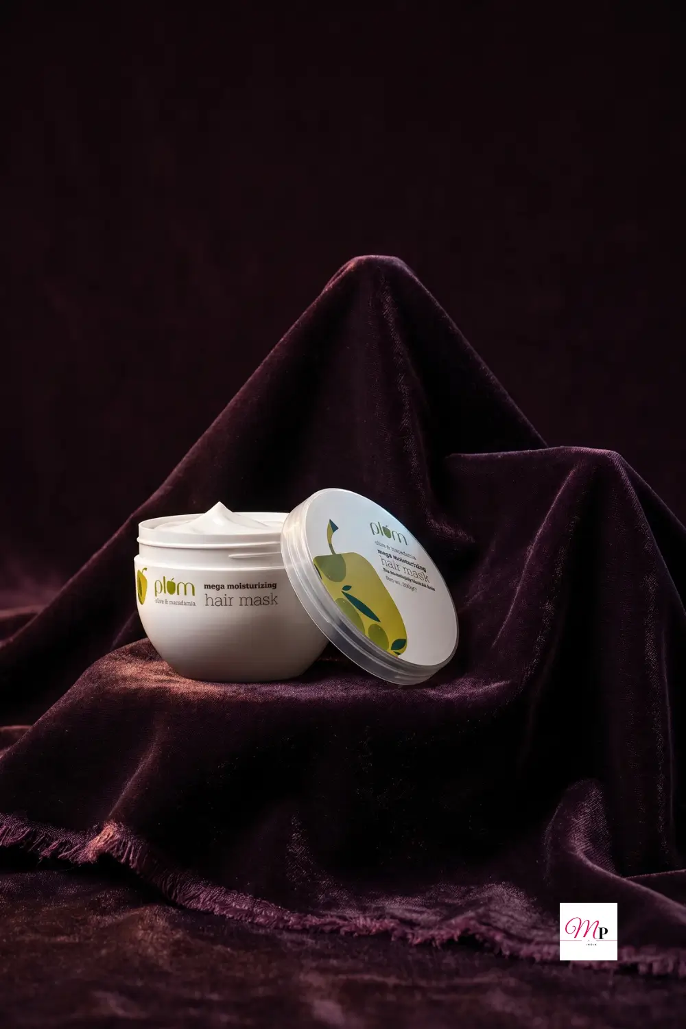 Plum Olive Macadamia hair mask jar on deep plum velvet draping with dramatic lighting — deep conditioning hair treatment for damaged hair
