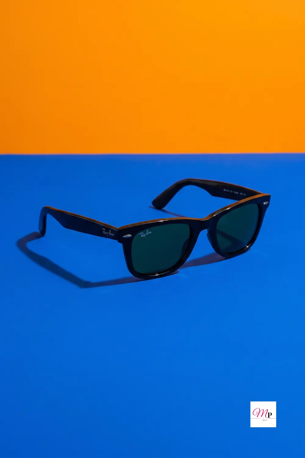 Bold color pop product photography of unisex square sunglasses on blue and orange backdrop