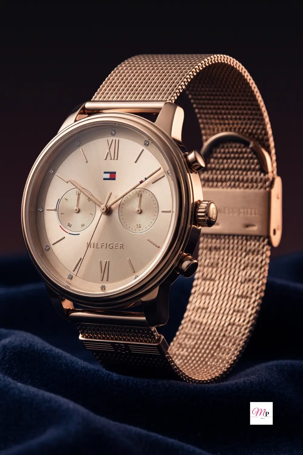 Tommy Hilfiger close-up of rose gold mesh weave chronograph sub-dials and stainless steel clasp on navy velvet
