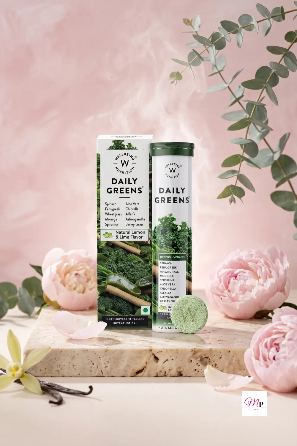 Wellbeing Nutrition Daily Greens lime flavor effervescent tablets for immunity and detox with box and tube on travertine stone with pink peonies