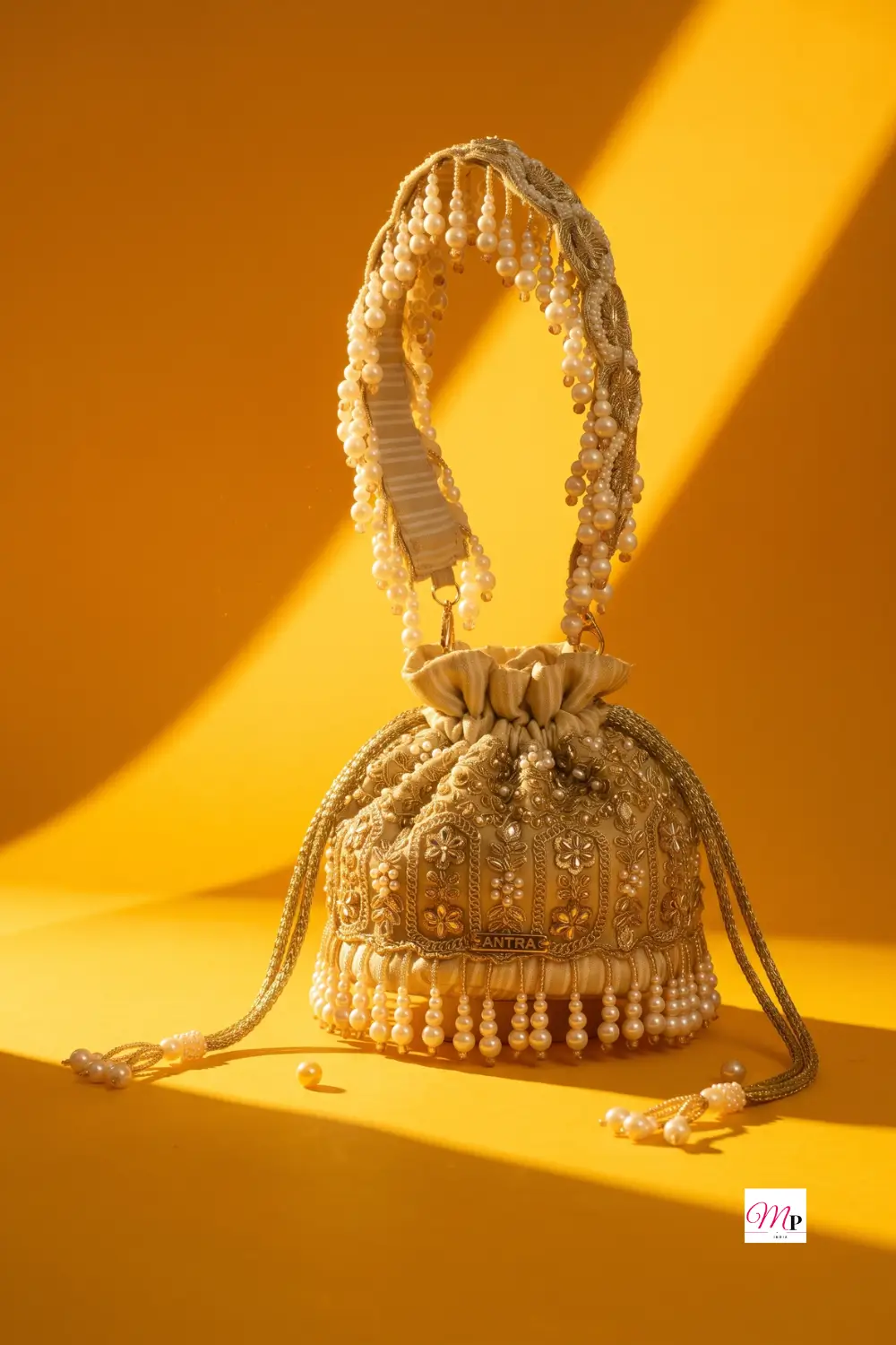 AMYRA gold floral-embellished potli bag with pearl handle and fringe for Ganesh Chaturthi festive styling — festive potli bag for women India