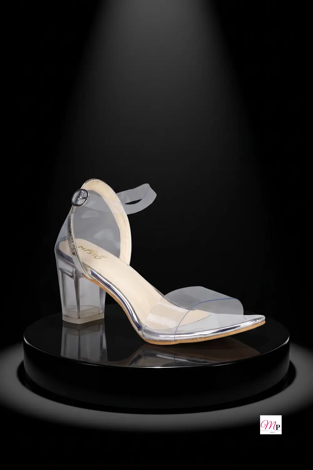 Misto clear strap block heel sandal side profile on black pedestal with transparent heel