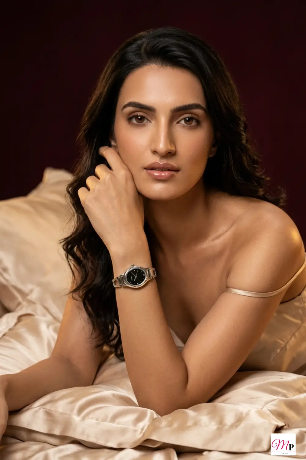 Sonata black dial silver bracelet watch resting on wrist against champagne silk sheets