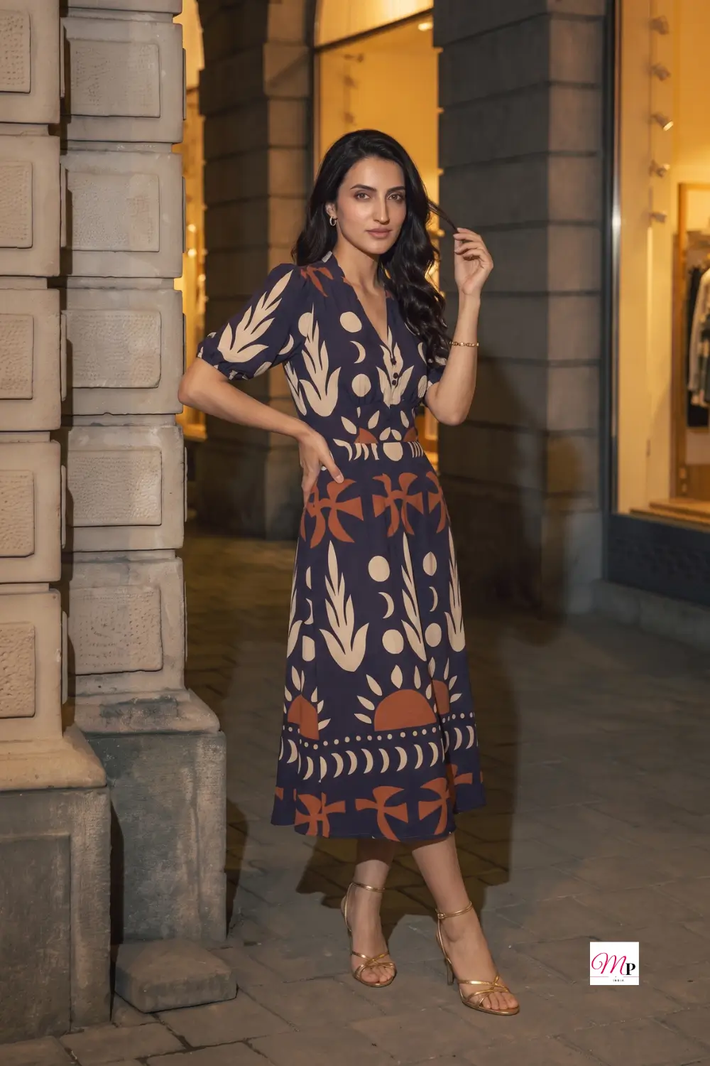 Full-length navy printed midi dress with A-line flare, twist front and gold strappy heels for a dinner date