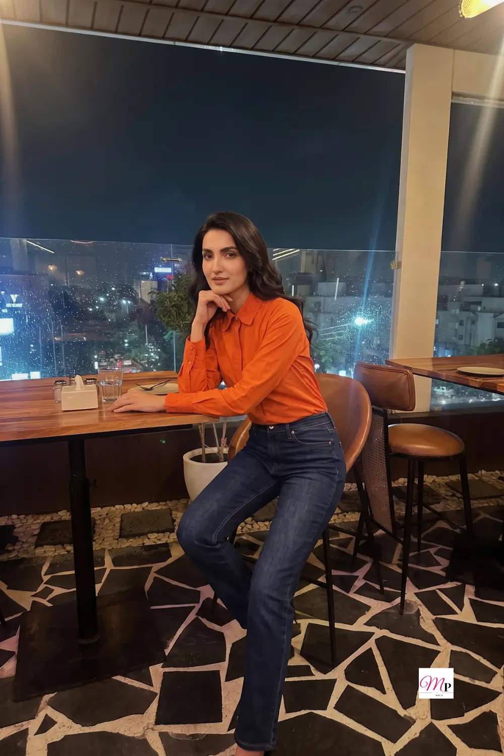 Red formal shirt transitioned to evening dinner look at rooftop restaurant, warm night lights
